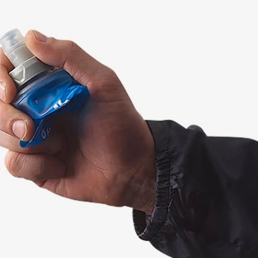 Hand holding a blue and gray device against a white background